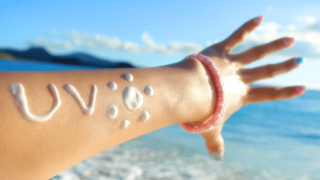 日焼け止めクリームで「UV」と落書きしてある女性の腕