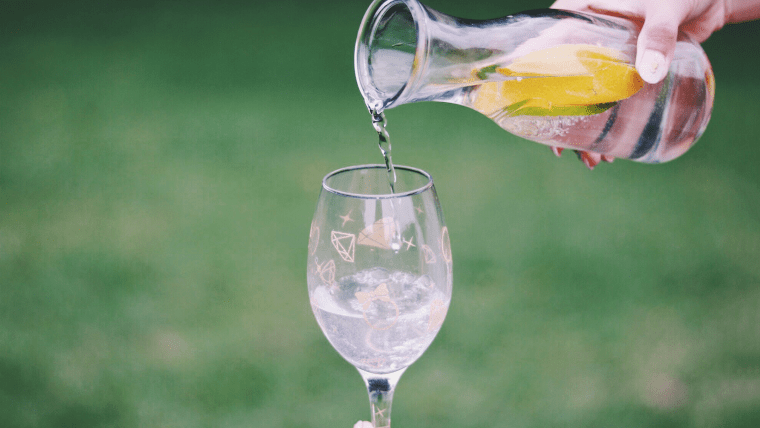ガラスのボトルからワイングラスへ水を継ぐ